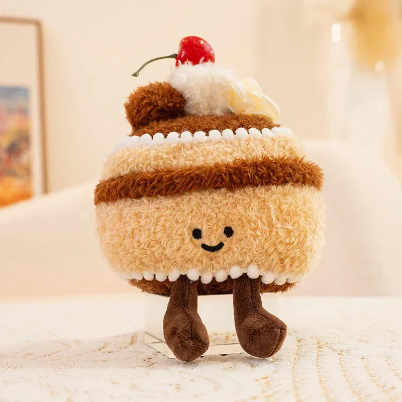 Kawaii plush toy resembling a cake with a cherry on top, sitting on a surface.