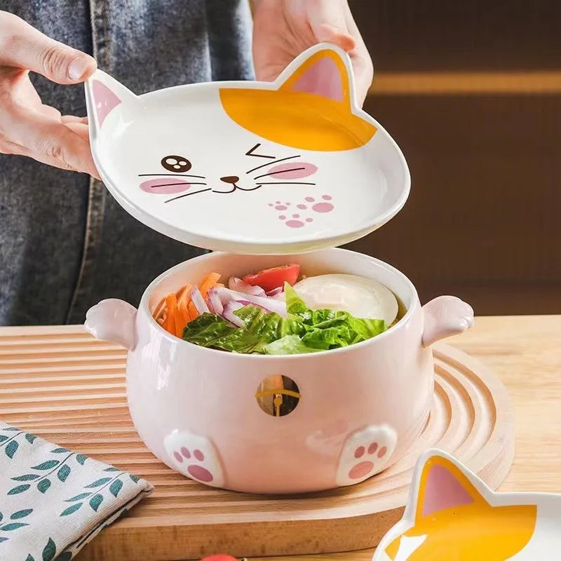 A hand holding a cat shaped kawaii ramen bowl