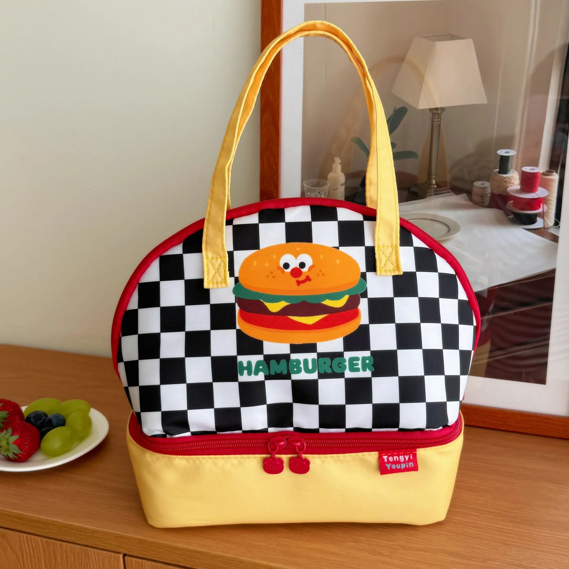 Checkered kawaii lunch bag with hamburger design on a wooden surface