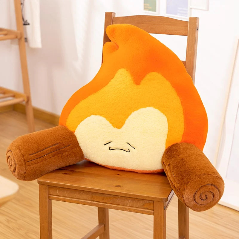 Flame-shaped kawaii plush toy with arms on a wooden chair in a room.