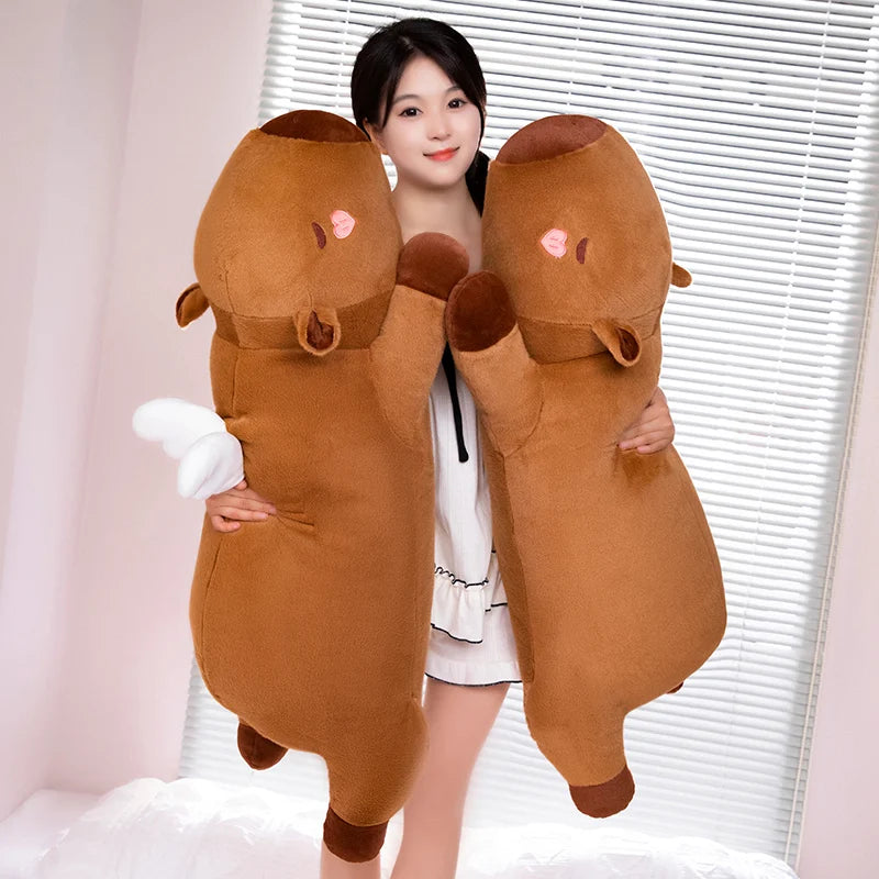 Person holding a large brown kawaii plush toy resembling a bear in front of a window with blinds.