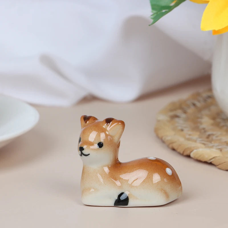 Small ceramic deer kawaii chopstick holders on a light surface with a blurred background