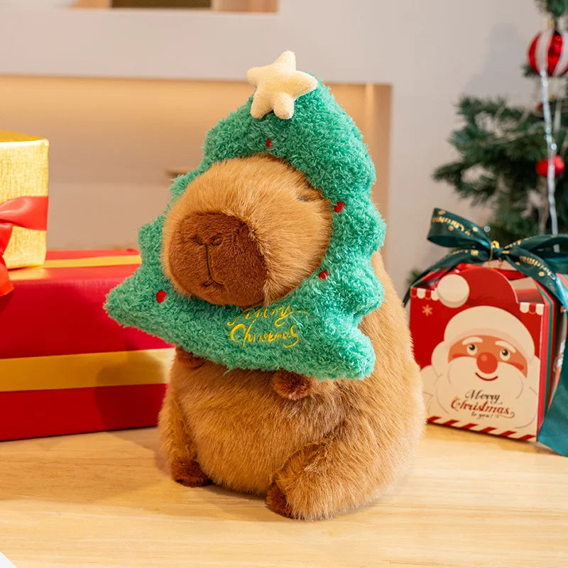 Kawaii plush toy resembling a bear in a Christmas tree costume with presents and a Santa Claus box in the background.