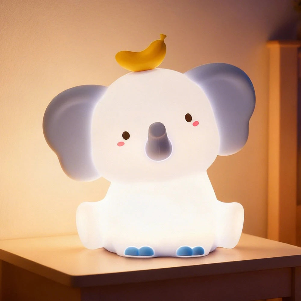 Cute elephant-shaped kawaii night light with a banana on its head, glowing softly.