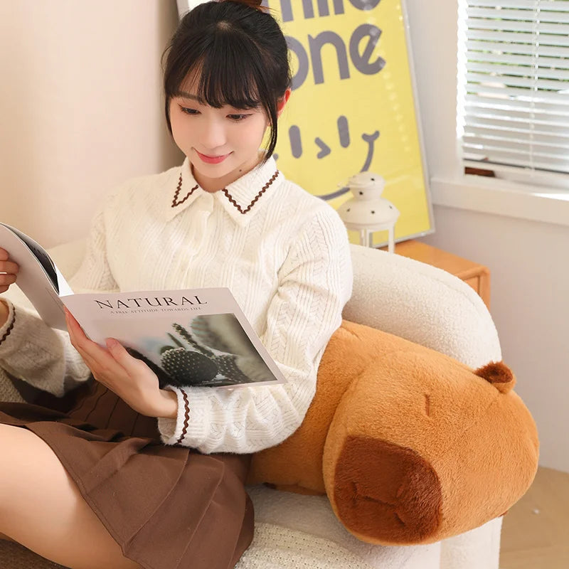 Woman reading a magazine on a large kawaii plush dog pillow in a cozy room.