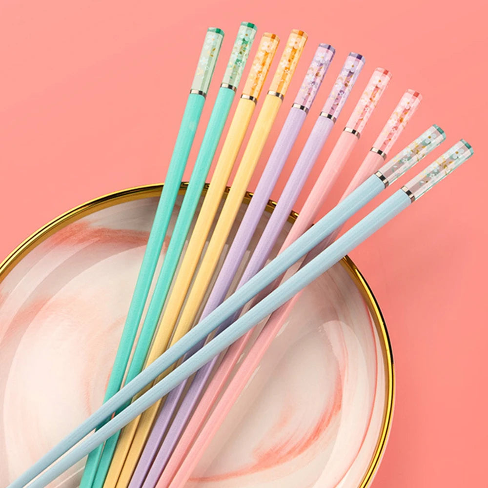 Set of colorful kawaii chopsticks on a pink background