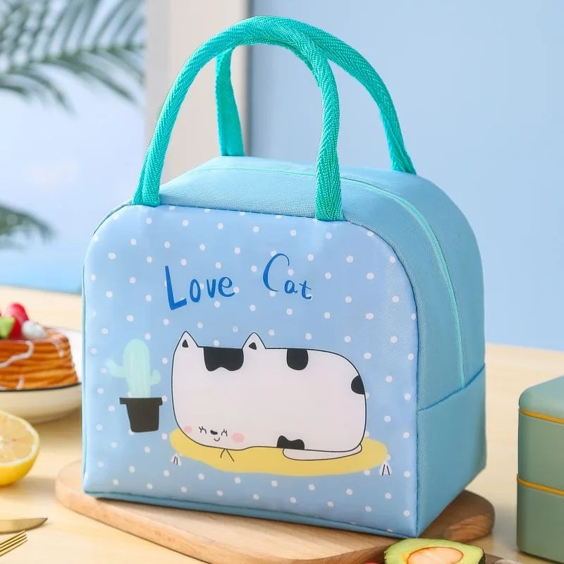 Blue kawaii lunch bag with a cat illustration and 'Love Cat' text on a table.