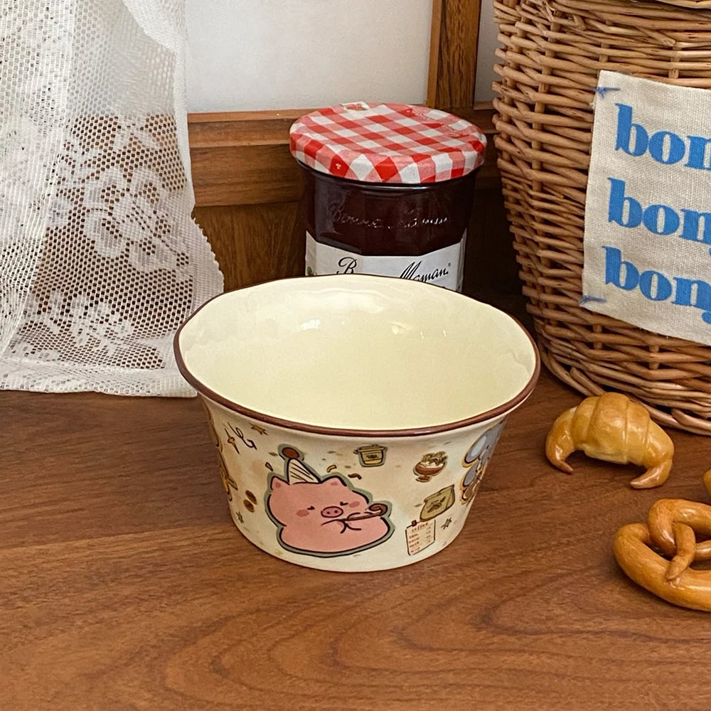 Ceramic kawaii ramen bowl with cartoon design on a wooden surface, next to a jar of jam and a basket.