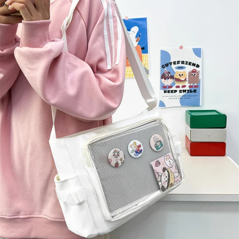 Person wearing a pink outfit with a white Kawaii crossbody bag featuring cartoon characters, in front of a shelf with colorful boxes.