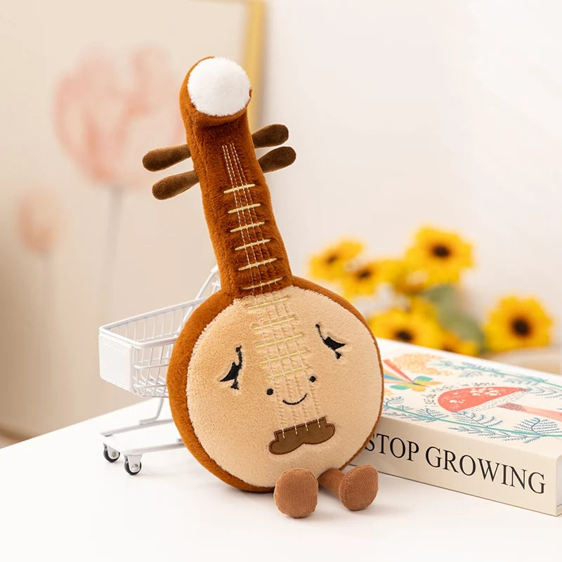 Kawaii plush toy resembling a musical instrument with a face on a surface with a book and flowers in the background.