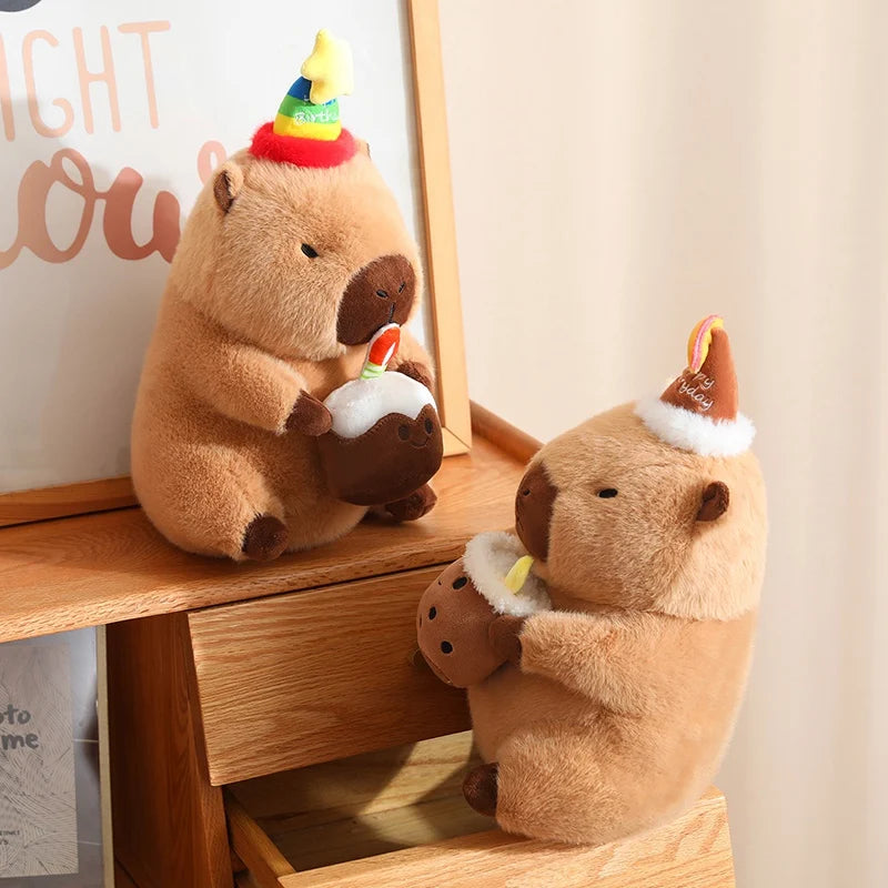 Two capybara plush toys with party hats on a wooden surface.