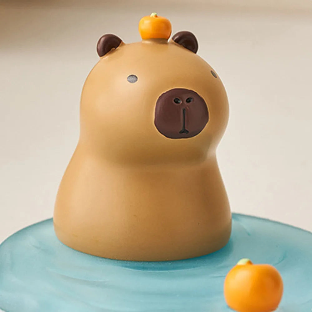 Kawaii phone holder of a capybara with small pumpkins on a beige background