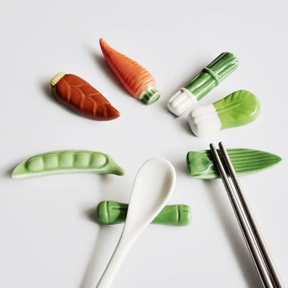 Set of ceramic kawaii chopstick holders shaped like vegetables on a white background